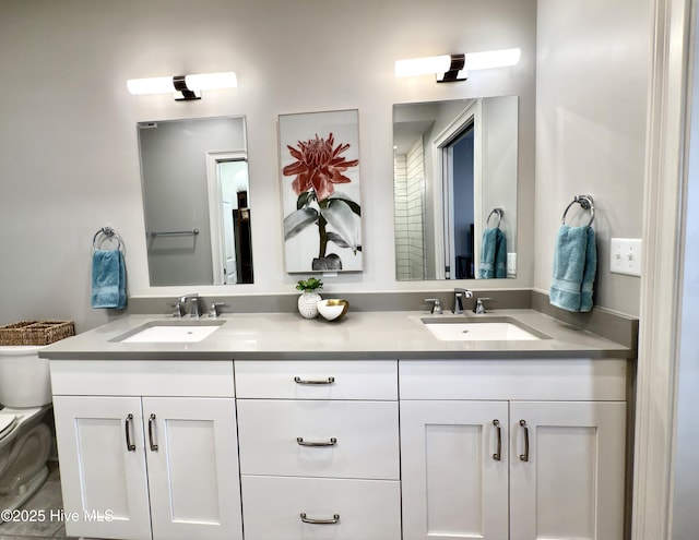 full bathroom with a sink, double vanity, and toilet