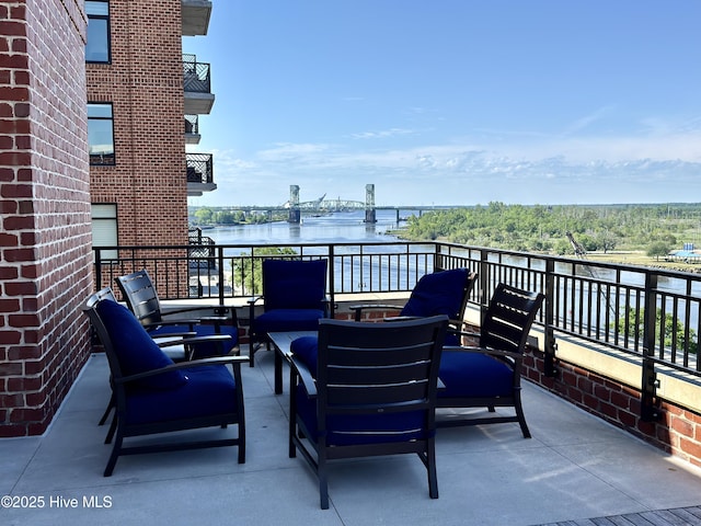 view of patio / terrace featuring a water view, an outdoor living space, and a balcony