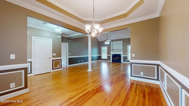 interior space featuring a fireplace, ceiling fan with notable chandelier, ornamental molding, and light wood-style flooring