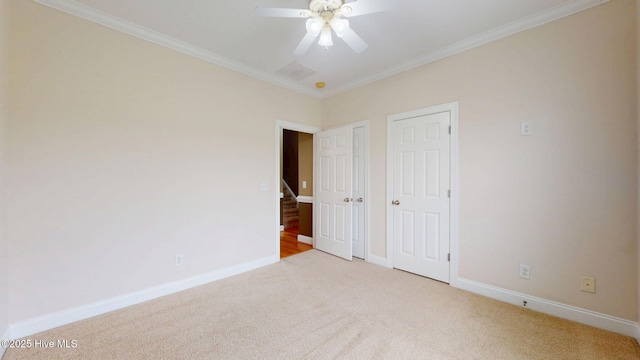 unfurnished bedroom featuring ornamental molding, two closets, carpet floors, a ceiling fan, and baseboards