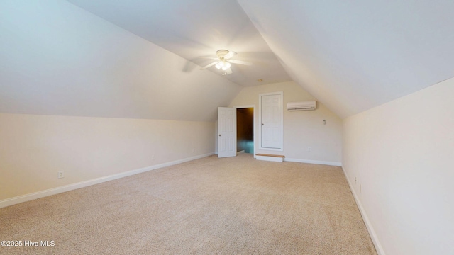 additional living space featuring a ceiling fan, an AC wall unit, baseboards, vaulted ceiling, and light colored carpet