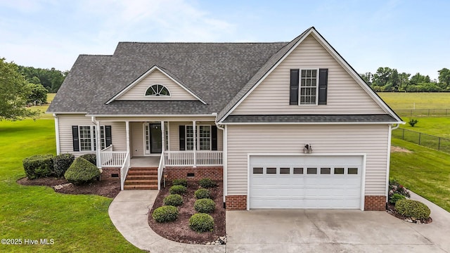 traditional-style home featuring covered porch, fence, a front lawn, a shingled roof, and driveway