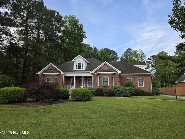 219 Drake Lndg, New Bern, NC 28560 - view of front of house with a front yard, a porch, brick siding, and fence
