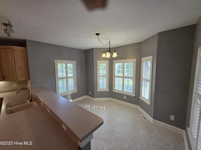 219 Drake Lndg, New Bern, NC 28560 - kitchen featuring light tile patterned floors, an inviting chandelier, visible vents, a sink, and backsplash