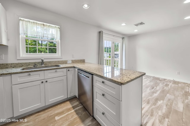 1406 Silverbrook Rd, Oriental, NC 28571 - kitchen with dishwasher, a sink, light wood-type flooring, a peninsula, and white cabinets