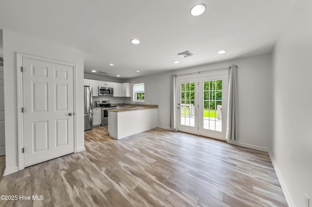 1406 Silverbrook Rd, Oriental, NC 28571 - kitchen featuring appliances with stainless steel finishes, white cabinets, recessed lighting, a peninsula, and light wood-style flooring