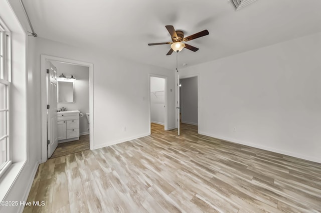 1406 Silverbrook Rd, Oriental, NC 28571 - unfurnished bedroom featuring light wood-style floors, baseboards, ensuite bath, a walk in closet, and ceiling fan