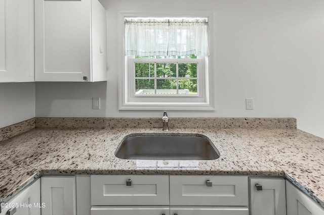 1406 Silverbrook Rd, Oriental, NC 28571 - kitchen featuring a sink, white cabinets, and light stone counters