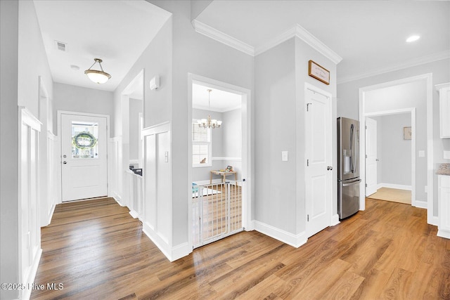 foyer entrance with a wealth of natural light, visible vents, and wood finished floors