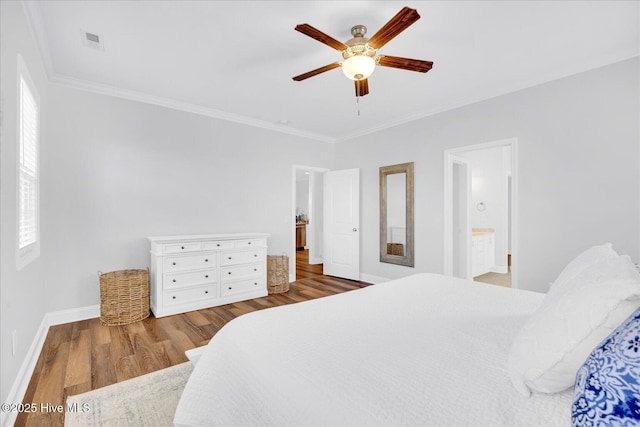 bedroom featuring visible vents, wood finished floors, baseboards, and ornamental molding