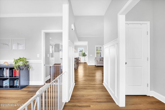hallway with crown molding, baseboards, and wood finished floors