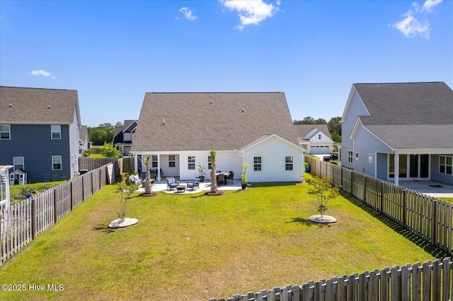 rear view of house featuring a yard, a patio, and a fenced backyard