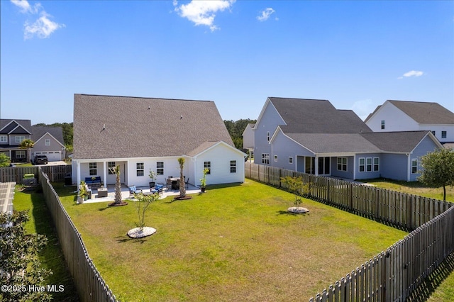 rear view of house featuring a lawn, a patio area, a residential view, and a fenced backyard