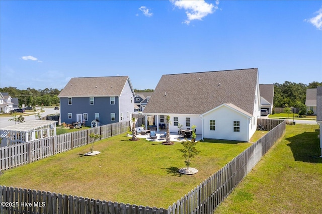 rear view of house with a yard, a fenced backyard, and a patio