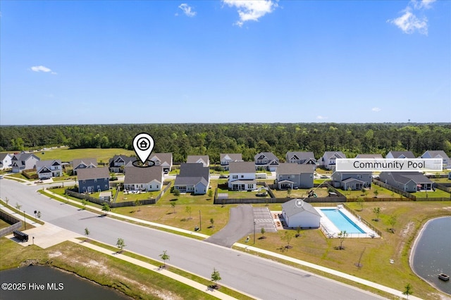 birds eye view of property with a water view, a residential view, and a view of trees