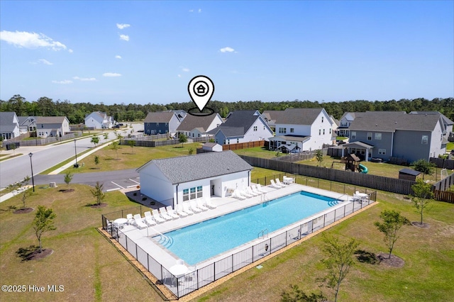 community pool with fence, a residential view, and a lawn