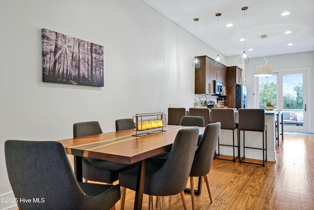 dining room with light wood-style flooring and recessed lighting