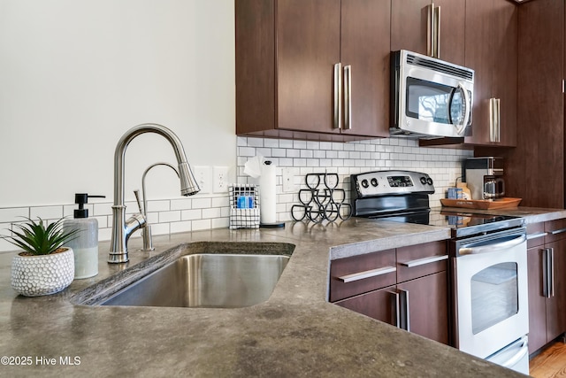 kitchen featuring appliances with stainless steel finishes, a sink, and tasteful backsplash
