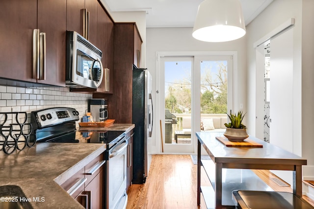 kitchen featuring appliances with stainless steel finishes, light wood-type flooring, tasteful backsplash, and dark brown cabinets