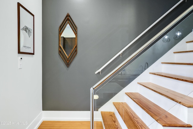 staircase with wood finished floors and baseboards