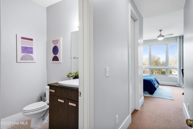 bathroom with toilet, vanity, a ceiling fan, and baseboards