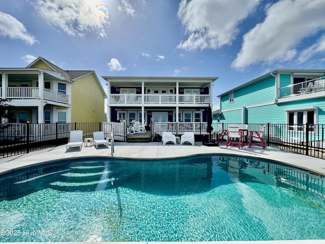 pool with fence, a patio, and french doors