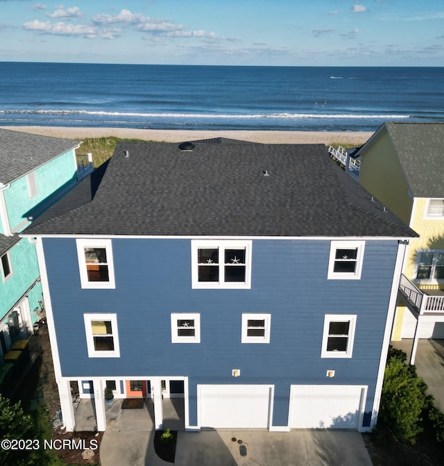 birds eye view of property with a water view and a beach view