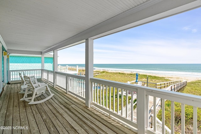 deck featuring a beach view and a water view