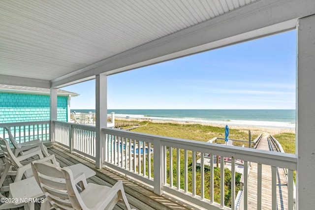 deck featuring a view of the beach and a water view