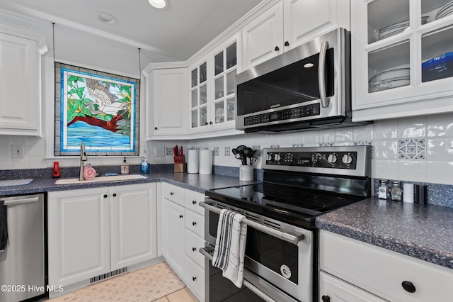 826 Fort Fisher Blvd N, Kure Beach, NC 28449 - kitchen with appliances with stainless steel finishes, a sink, dark countertops, and white cabinetry