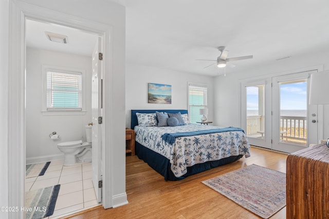826 Fort Fisher Blvd N, Kure Beach, NC 28449 - bedroom featuring access to exterior, multiple windows, light wood-style floors, and a ceiling fan