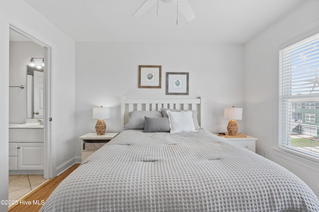 826 Fort Fisher Blvd N, Kure Beach, NC 28449 - bedroom featuring multiple windows, light wood-style flooring, ensuite bath, and ceiling fan