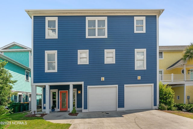 coastal home with concrete driveway and a garage