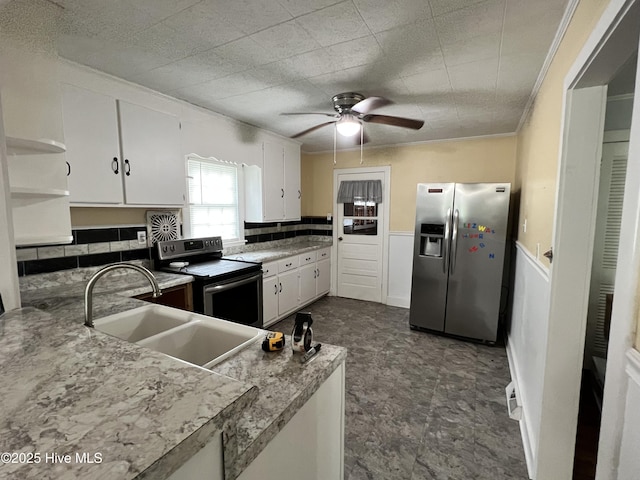 214 S Graham St, Wallace, NC 28466 - kitchen featuring stainless steel appliances, a sink, white cabinets, ceiling fan, and a wainscoted wall