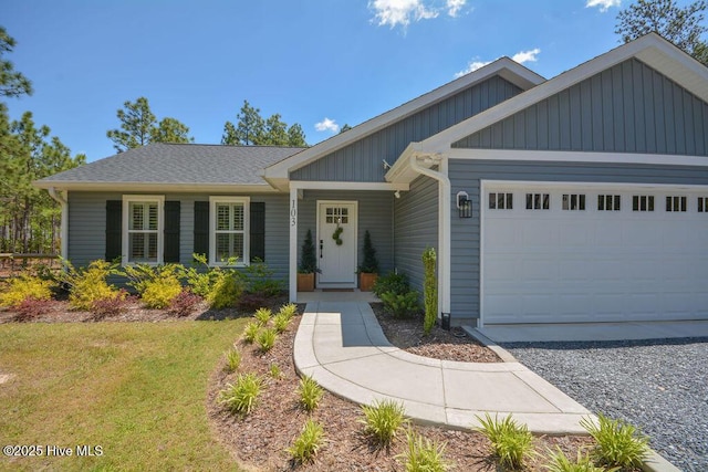 ranch-style home featuring a front yard, an attached garage, and board and batten siding