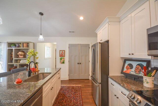 kitchen with a sink, white cabinets, dark wood finished floors, visible vents, and appliances with stainless steel finishes