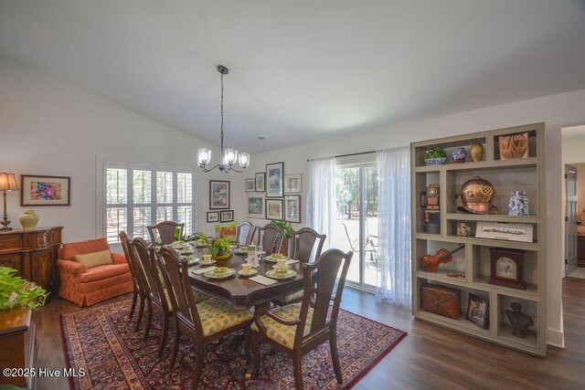 dining area featuring a notable chandelier, dark wood-style floors, and vaulted ceiling
