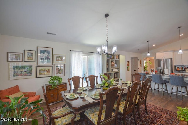 dining space featuring vaulted ceiling, plenty of natural light, visible vents, and a chandelier