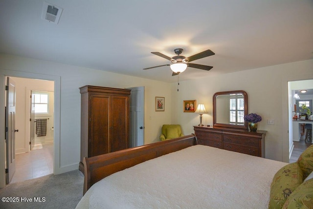 carpeted bedroom featuring visible vents, baseboards, and a ceiling fan