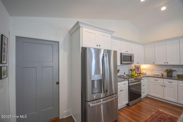 kitchen with dark wood-style flooring, lofted ceiling, white cabinets, and appliances with stainless steel finishes