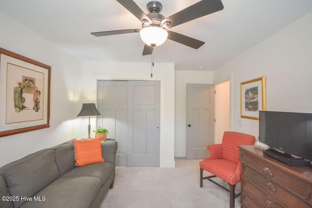living room featuring light colored carpet and a ceiling fan