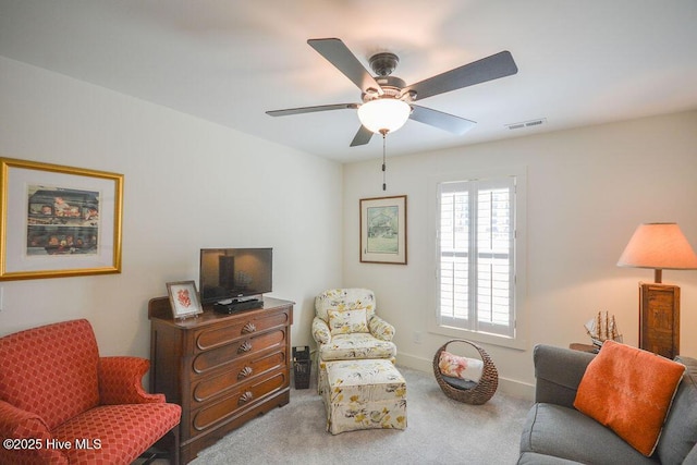 living area with baseboards, ceiling fan, visible vents, and carpet