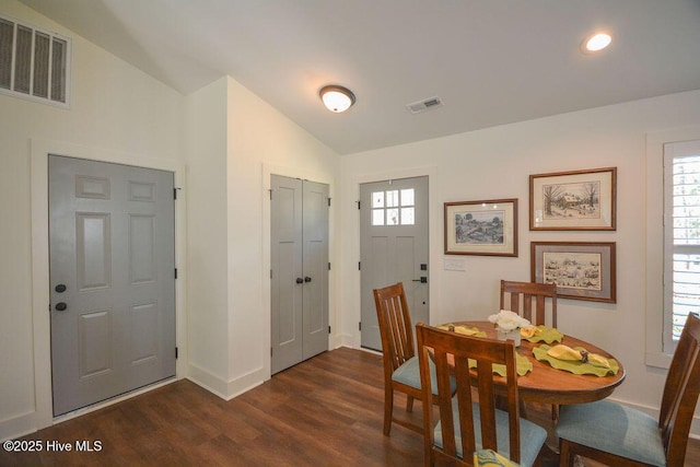 dining room featuring lofted ceiling, baseboards, dark wood finished floors, and visible vents
