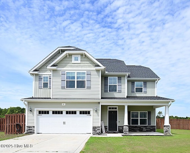 911 Needlerush Rd, Sneads Ferry, NC 28460 - craftsman-style home with a garage, a porch, driveway, and stone siding