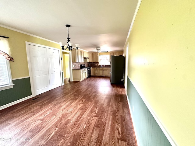 706 E Country Club Dr, Tarboro, NC 27886 - unfurnished living room with a wainscoted wall, an inviting chandelier, crown molding, and dark wood-style floors