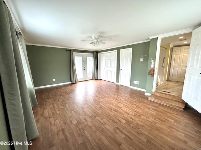 706 E Country Club Dr, Tarboro, NC 27886 - unfurnished bedroom featuring wood finished floors, multiple closets, crown molding, ceiling fan, and baseboards