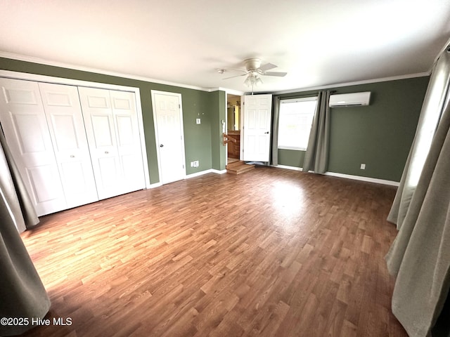 706 E Country Club Dr, Tarboro, NC 27886 - unfurnished bedroom with two closets, crown molding, a wall mounted AC, and wood finished floors