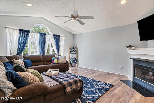 4 Brunswick Ln, Pinehurst, NC 28374 - living area with ceiling fan, wood finished floors, lofted ceiling, a textured ceiling, and a fireplace with flush hearth