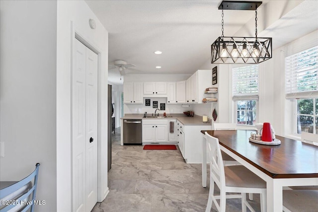 4 Brunswick Ln, Pinehurst, NC 28374 - kitchen featuring white cabinetry, a sink, light countertops, a textured ceiling, and decorative light fixtures