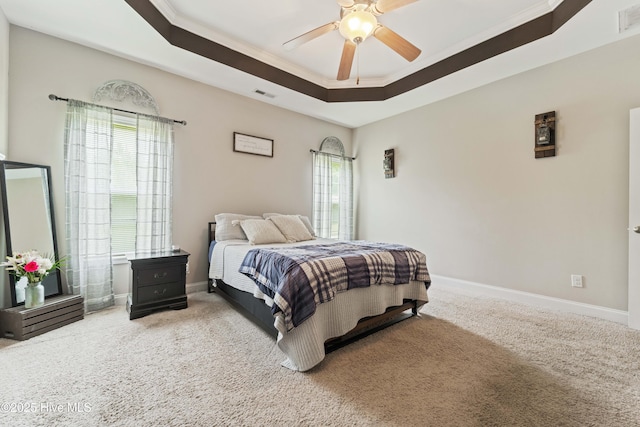 carpeted bedroom featuring crown molding, visible vents, baseboards, and a raised ceiling